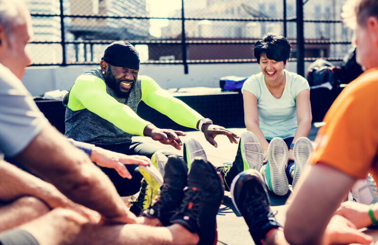 Group of people doing outdoor bootcamp workout in a park